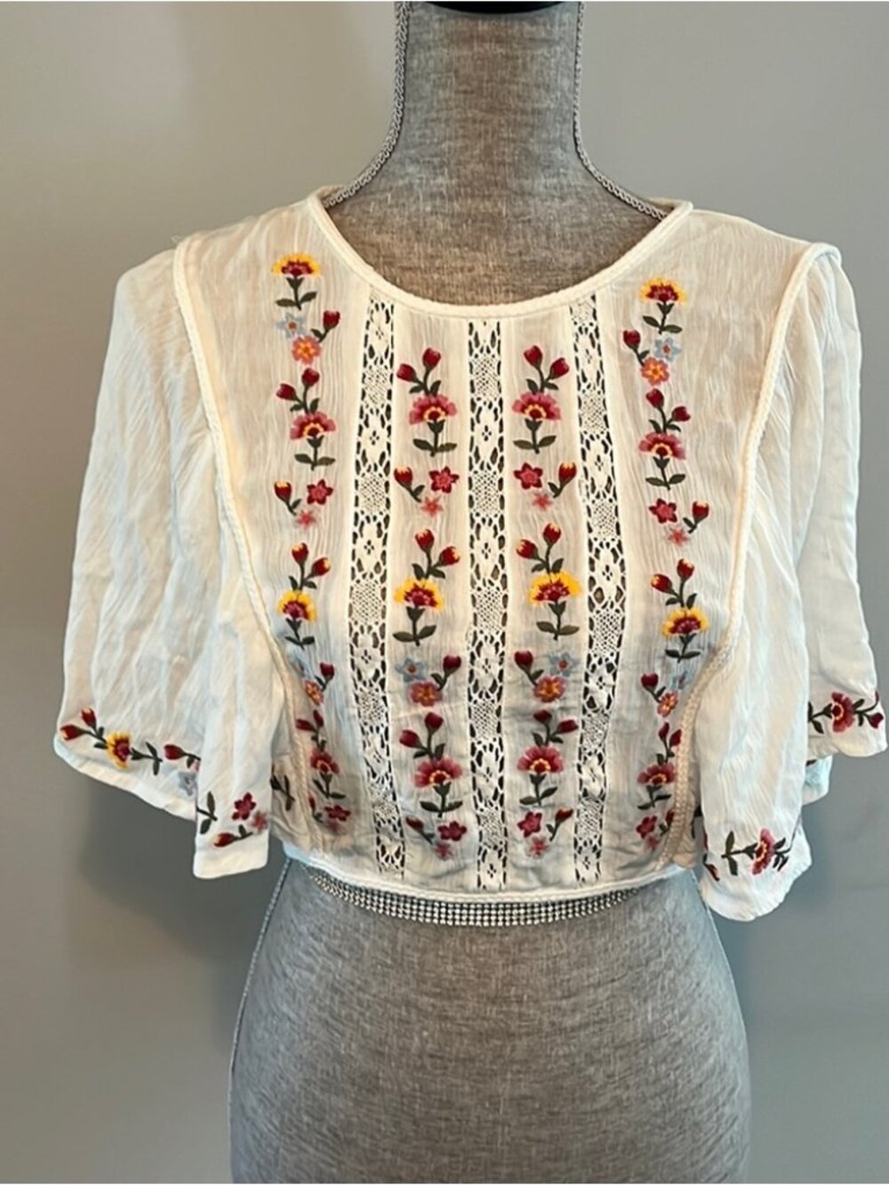 Cropped blouse with embroidery and lace open back.